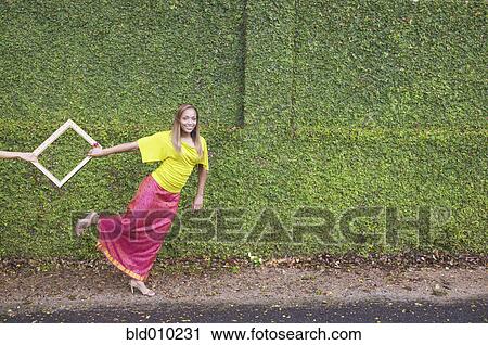 Stock Image - Young woman pulling a frame. Fotosearch