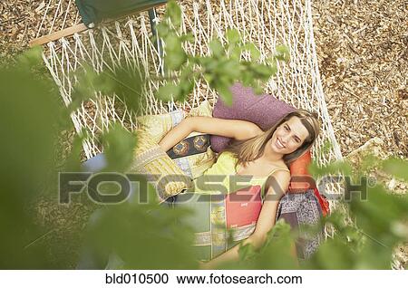 Stock Image - Young woman resting on hammock. Fotosearch