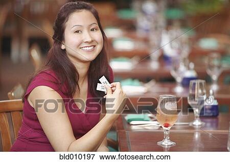 Stock Photo - Young woman sitting in a restaurant. Fotosearch