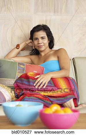 Young woman sitting on couch View Large Photo Image Stock Photo - Young woman sitting on couch. Fotosearch