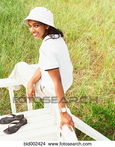 Young woman sitting on railing View Large Photo Image Picture - Young woman sitting on railing. Fotosearch