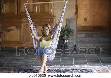 Young woman sitting on swing View Large Photo Image Stock Photography - Young woman sitting on swing. Fotosearch