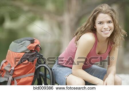 Young woman smiling outdoors View Large Photo Image Stock Photograph - Young woman smiling outdoors. Fotosearch