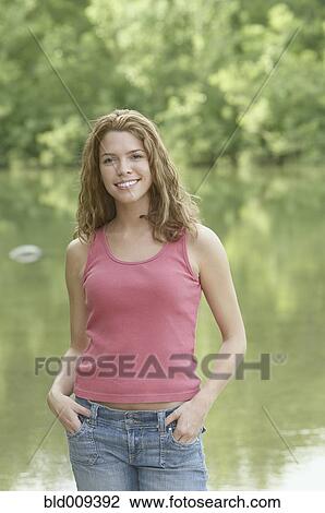 Young woman standing by a lake View Large Photo Image Stock Image - Young woman standing by a lake. Fotosearch