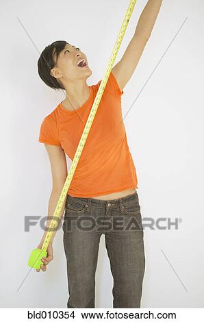 Young woman stretching a measuring tape View Large Photo Image Picture - Young woman stretching a measuring tape. Fotosearch