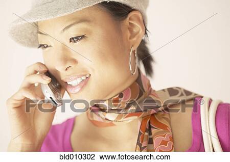 Stock Image - Young woman talking on a mobile phone. Fotosearch
