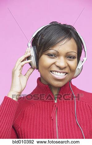 Stock Image - Young woman wearing headphones. Fotosearch