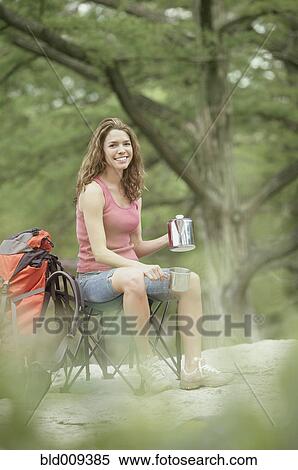 Stock Photography - Young woman with camping gear. Fotosearch