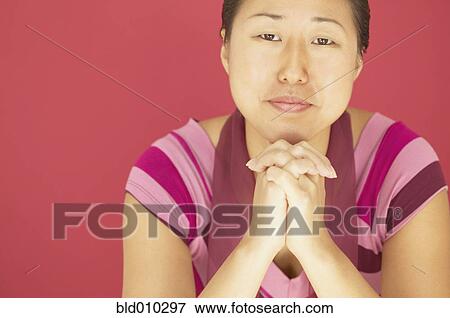 Young woman with chin resting on her hands View Large Photo Image Stock Photo - Young woman with chin resting on her hands. Fotosearch