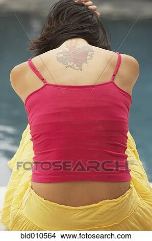 Young woman with tattoo on back View Large Photo Image Picture - Young woman with tattoo on back. Fotosearch