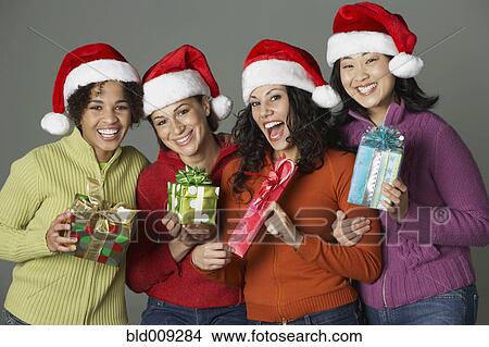 Young women holding holiday gifts View Large Photo Image Picture - Young women holding holiday gifts. Fotosearch