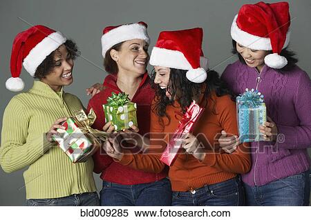 Stock Photography - Young women holding holiday gifts. Fotosearch