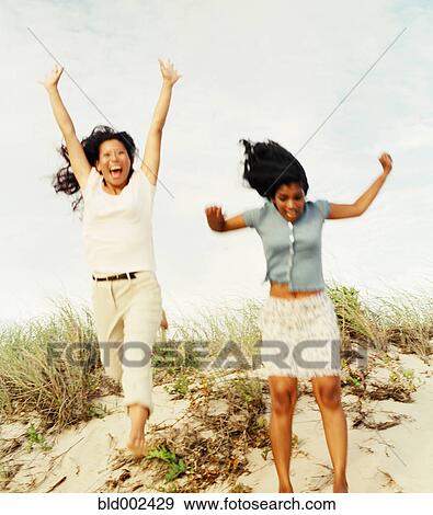 Young women jumping at beach View Large Photo Image Stock Photo - Young women jumping at beach. Fotosearch