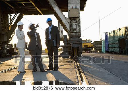 Stock Photograph - African American businesspeople wearing hardhats. Fotosearch