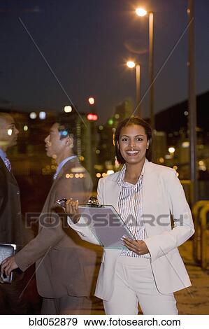 Stock Photo - African American businesswoman holding clipboard. Fotosearch