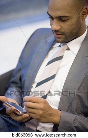 Stock Image - African businessman holding electronic organizer. Fotosearch