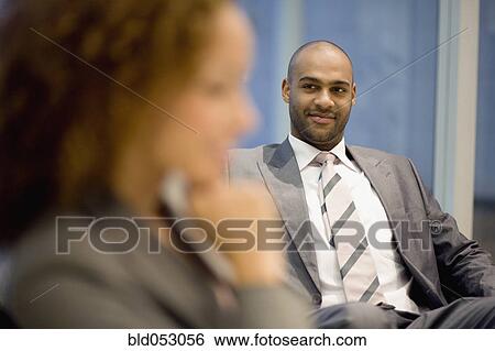Stock Photograph - African businessman looking at coworker. Fotosearch