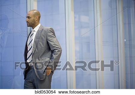 African businessman looking out window View Large Photo Image Picture - African businessman looking out window. Fotosearch