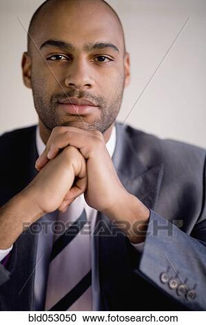 African businessman resting chin on hands View Large Photo Image Stock Image - African businessman resting chin on hands. Fotosearch
