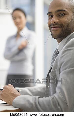 African businessman sitting at table View Large Photo Image Picture - African businessman sitting at table. Fotosearch