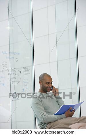 Stock Image - African businessman talking on cell phone. Fotosearch