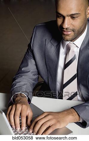 African businessman typing on laptop View Large Photo Image Stock Photo - African businessman typing on laptop. Fotosearch