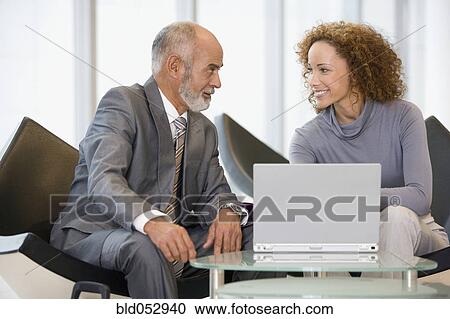 Stock Image - African businesspeople next to laptop. Fotosearch