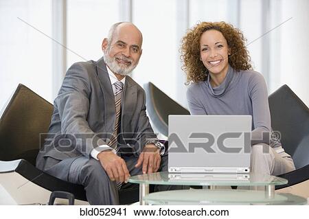 Stock Image - African businesspeople next to laptop. Fotosearch