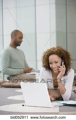 Stock Image - African businesspeople working on floor. Fotosearch