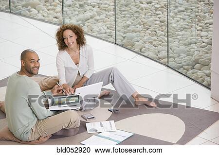 Stock Image - African businesspeople working on floor. Fotosearch