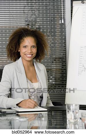 Picture - African businesswoman at conference table. Fotosearch