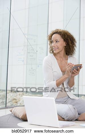 Stock Photo - African businesswoman holding electronic organizer. Fotosearch