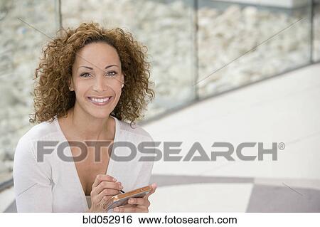 Stock Photograph - African businesswoman holding electronic organizer. Fotosearch