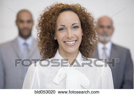 Stock Image - African businesswoman in front of coworkers. Fotosearch