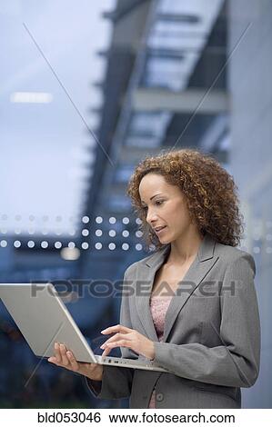 African businesswoman looking at laptop View Large Photo Image Stock Photograph - African businesswoman looking at laptop. Fotosearch