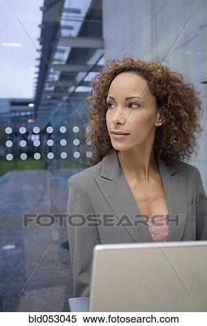Stock Photography - African businesswoman next to laptop. Fotosearch