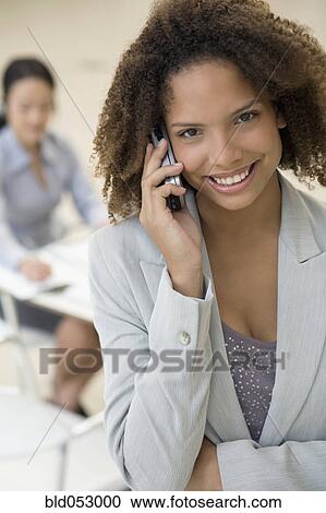 Stock Image - African businesswoman talking on cell phone. Fotosearch