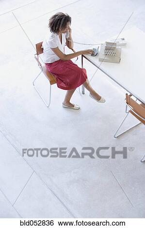 Stock Photograph - African businesswoman talking on telephone. Fotosearch