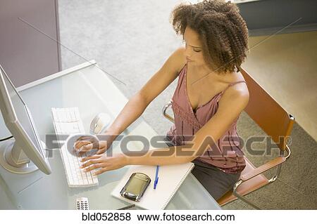 Stock Photo - African businesswoman typing on computer. Fotosearch