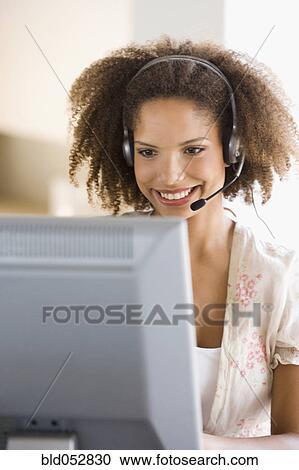 Stock Image - African businesswoman wearing headset. Fotosearch