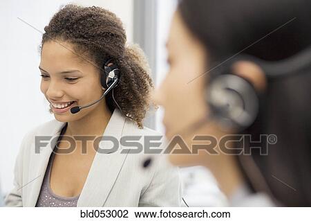 Stock Image - African businesswoman wearing headset. Fotosearch