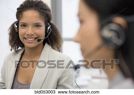 Stock Image - African businesswoman wearing headset. Fotosearch