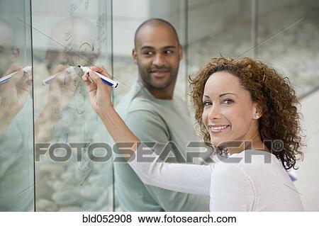 Stock Photo - African businesswoman writing on clear dry erase board. Fotosearch