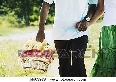 Picture - African couple carrying picnic basket. Fotosearch