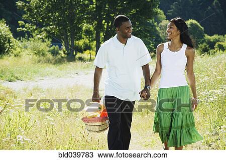 Stock Image - African couple carrying picnic basket. Fotosearch