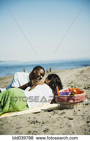 African couple having picnic on beach View Large Photo Image Stock Photo - African couple having picnic on beach. Fotosearch