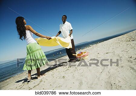 African couple having picnic on beach View Large Photo Image Stock Photograph - African couple having picnic on beach. Fotosearch