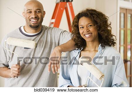 African couple holding paint rollers View Large Photo Image Stock Photo - African couple holding paint rollers. Fotosearch