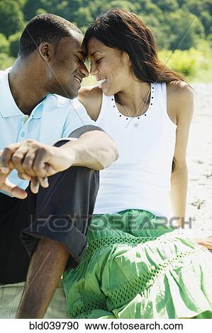 Stock Image - African couple hugging on beach. Fotosearch