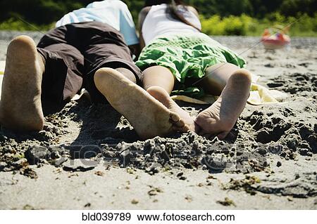 African couple laying on beach View Large Photo Image Stock Photo - African couple laying on beach. Fotosearch